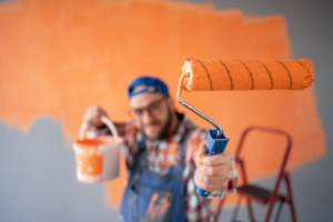 a closeup of a man holding a paint roller
