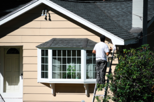 a homeowner painting their house’s exterior